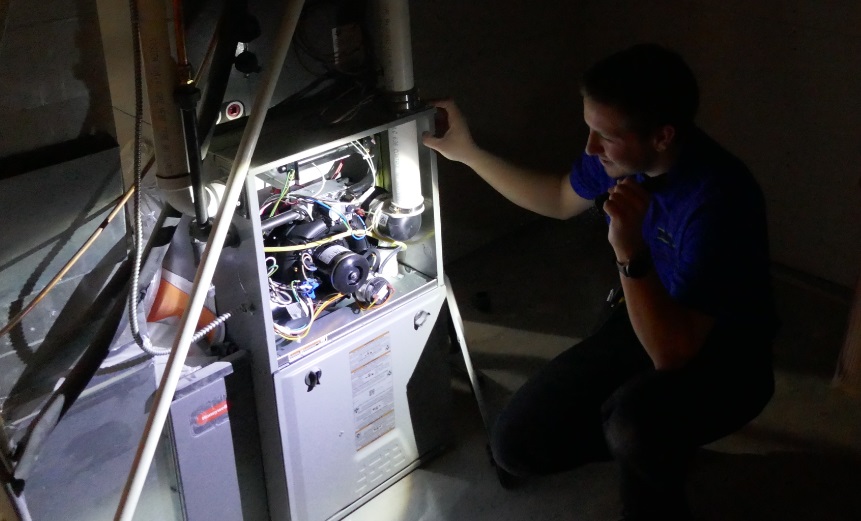 inspecting furnace in basement HVAC system